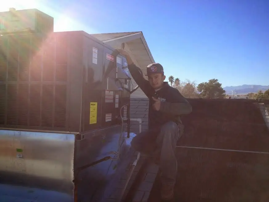 HVAC technician performing HVAC Inspection on a rooftop unit in Georgetown